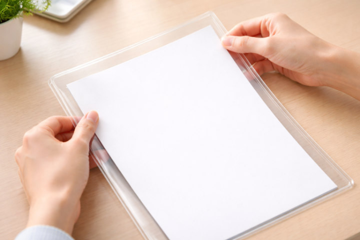 A4用紙をクリアファイルに入れる手元。サイズの違いと余白を確認している様子