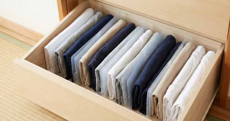 クローゼットの引き出し内で、カットしたクリアファイルを仕切りに使ってTシャツをきれいに立てて収納している様子